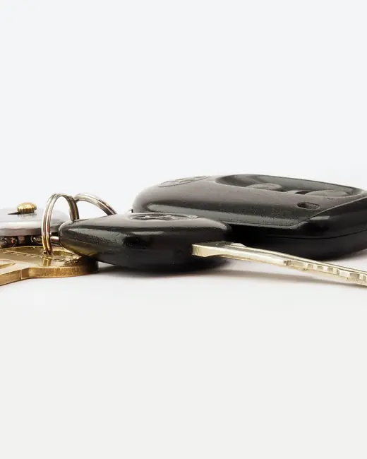 Car keys and a remote on a white surface